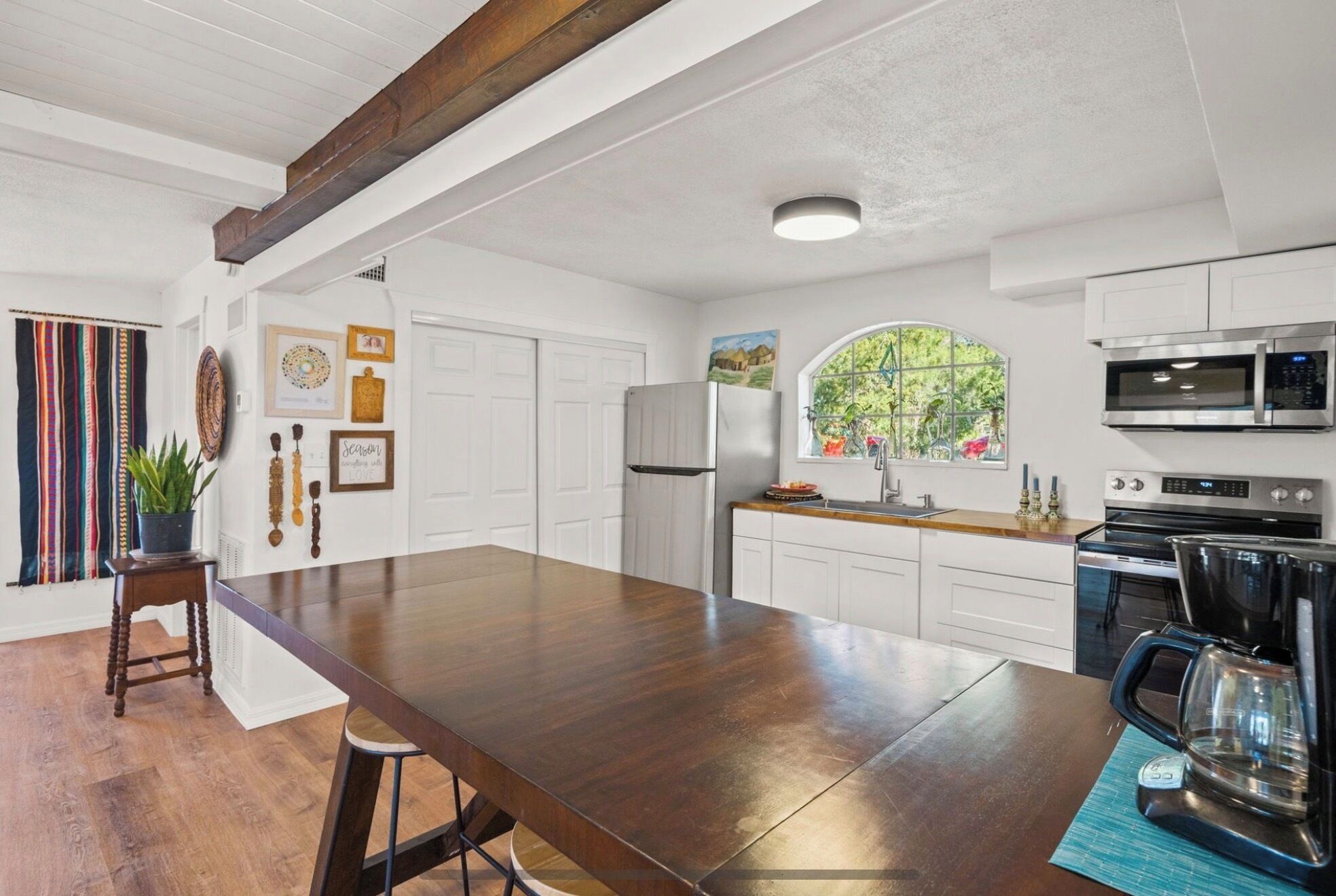 A spacious kitchen with white cabinetry, a large island, and modern appliances.