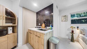 Una cocina moderna con armarios de madera, un lavamanos y un cubo de basura compacto.