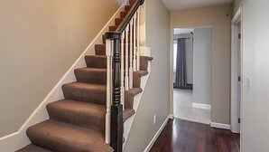 A staircase with carpeted steps and a wooden handrail, leading to a door. - World Cup Boston Private 6-Acre Estate Sleeps 16 Less than 18 Min From Gillette (Taunton)