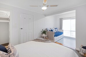 A bedroom with a bed, a ceiling fan, a window, and a door. - Charming CBD cottage - walk everywhere (Mount Gambier)