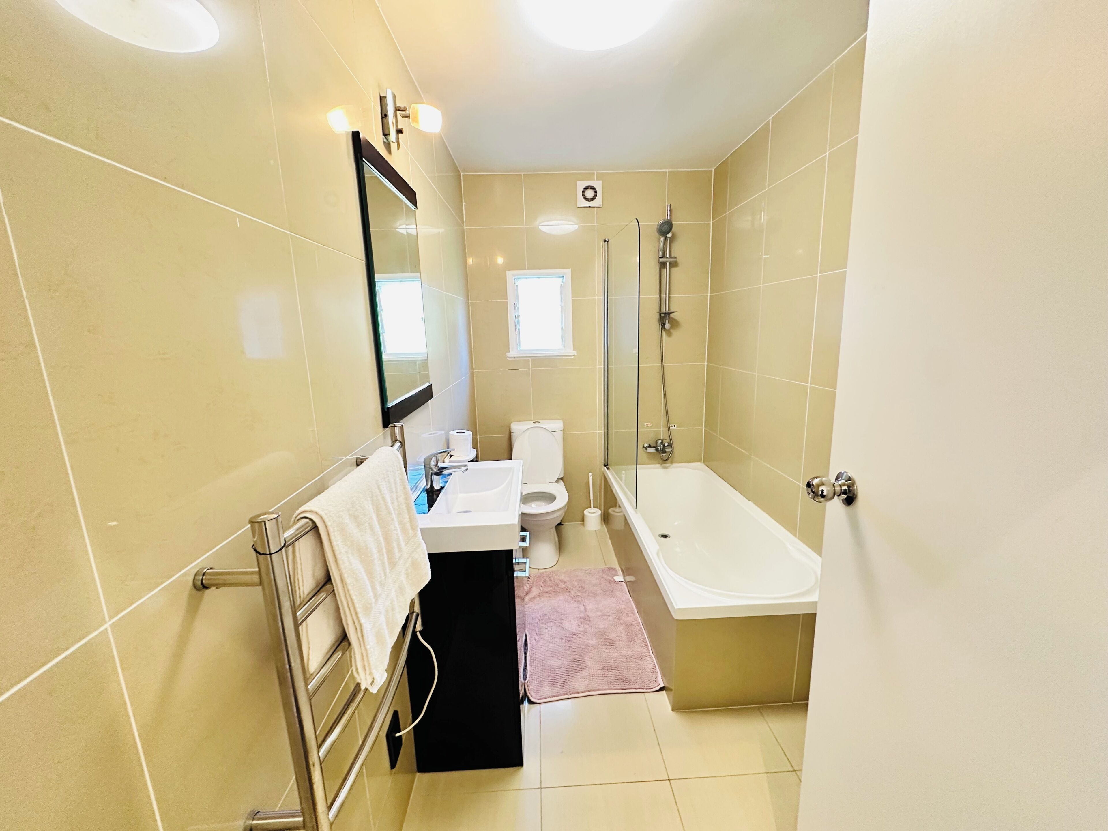 Une salle de bain comprenant des toilettes, un lavabo, un miroir et une baignoire.