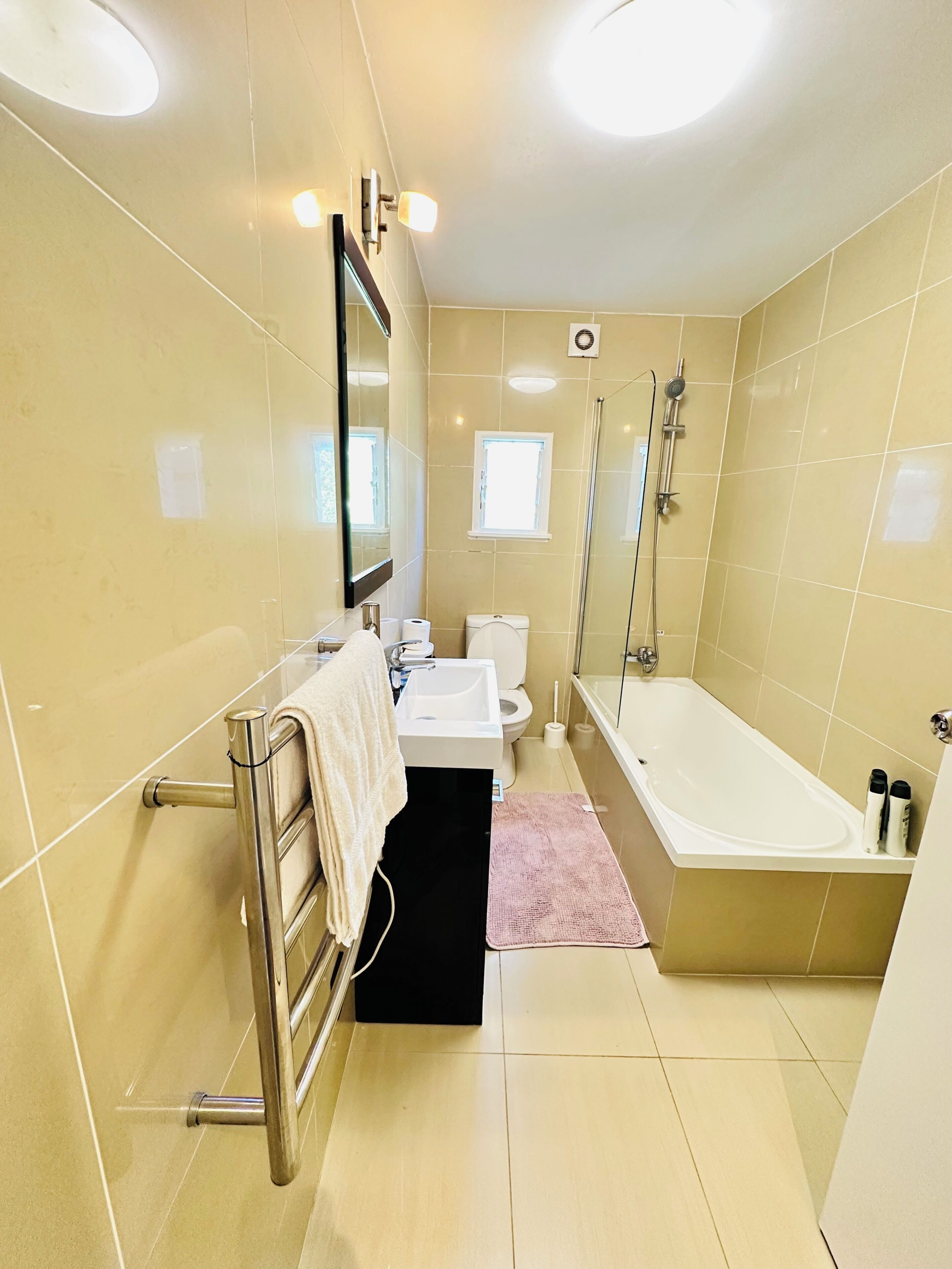 A modern bathroom with a toilet, sink, and bathtub.