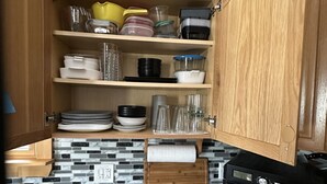 A kitchen with wooden cabinets, a countertop, and a microwave. - Cozy, peaceful cabin retreat with hot tub (Weld)
