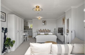 Ein Schlafzimmer mit Bett, Nachttischen, einer Stehlampe und einer Deckenleuchte.