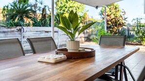 A wooden table with a potted plant, a tray with playing cards, and a white game board. - Cullen Bay Retreat | Pool, Balcony & Marina Stroll (Larrakeyah)