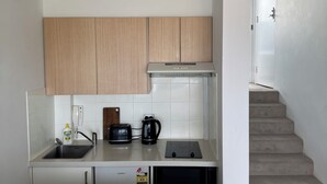 Une cuisine moderne équipée d’un four encastré, d’un grille-pain, d’une bouilloire et d’un évier.