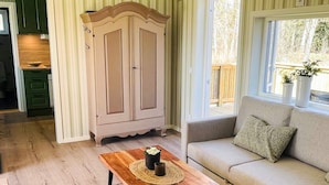 A living room with a sofa, a wooden coffee table, and a cabinet. - 4 Star Holiday Home in Bodafors (Bodafors)