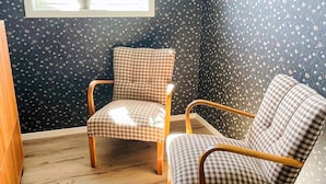 A room with two checkered chairs, a wooden floor, and patterned wallpaper. - 4 Star Holiday Home in Bodafors (Bodafors)
