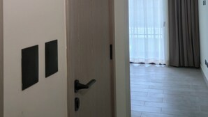 A hallway with a wooden door, a welcome sign, a window with curtains, and an air conditioning unit. - Cozy 1-bedroom condo with AC in welcoming Punta Cana (Punta Cana)