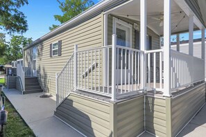 A single-story house with a front porch, a set of stairs leading to the entrance, and a small deck area. - Renovated Naples Retreat- Resort Pool & Game Room (Naples)