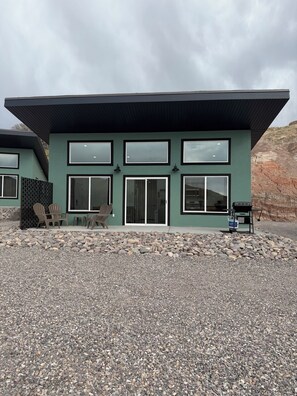 A modern building with multiple windows, a covered entrance, and outdoor seating. - Sunset Ridge #4 at The Hidden G Spot Villa's (Glenwood)