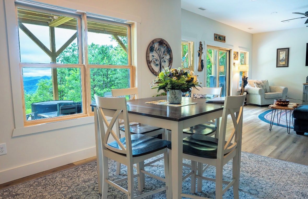 A dining area with a table, chairs, and a view of the outdoors.