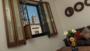 Ein Zimmer mit Fenster, einer Vase mit Blumen und Wänden mit runden Spiegeln.