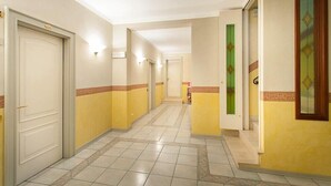 A hotel corridor with doors, light fixtures, and a tiled floor. - Hotel Gambara (Gambara)
