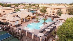 Ein Resort mit Swimmingpool, Liegestühlen, einer Basketball- und einer Tennisanlage.