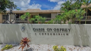 A sign for 'Oasis on Osprey Condominium' with a building in the background. - Cozy 2-bedroom 2nd floor, end unit condo in charming Sarasota (Sarasota)