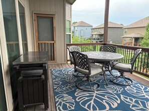 A balcony with a table and chairs, a grill, and a patterned rug. - Spacious KC World Cup Retreat   4 bath   Sleep 7   Free Parking   Entire Home (Kansas City)
