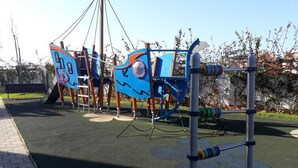 A playground with a climbing structure and a slide.