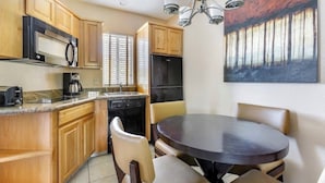 A kitchen with wooden cabinets, a microwave, a coffee maker, and a dining table with chairs. - Luxury Grand Vacation Stay in Mountainous Sedona (Sedona)