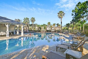 A swimming pool with lounge chairs and a covered seating area. - Emerald Escape| 4BR 30A | Sleeps 10 | 6 Seater Golf Cart + Bikes (Santa Rosa Beach)