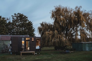 A small wooden cabin with a visible bedroom and a dining area.