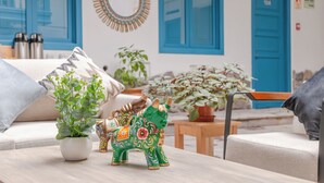 Una habitación con un sofá, una mesita, una figura decorativa de toro y una planta en maceta.
