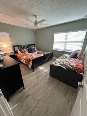 A bedroom with two beds, a desk, a ceiling fan, and a window with blinds. - Pet friendly pool oasis in Orlando (Orlando)