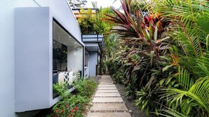 A modern building with a stone pathway leading to a glass door entrance. - Volcano-Lux Arenal 3BR House (Tanque)