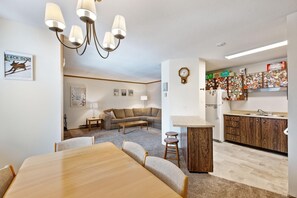 A modern apartment with a dining area, living room, and kitchen.