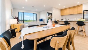 Un salón moderno con comedor, ventanas amplias y cocina.