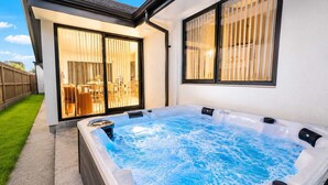 Un jacuzzi con vista despejada del entorno, incluyendo un patio y un edificio con grandes ventanales.