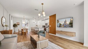 Ein modernes Wohnzimmer mit Sofa, Couchtisch und Essbereich.