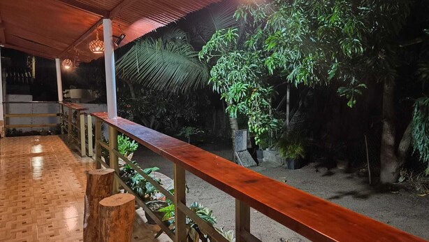Un espace intérieur doté d’un plancher en bois, d’une rambarde en bois et de diverses plantes.