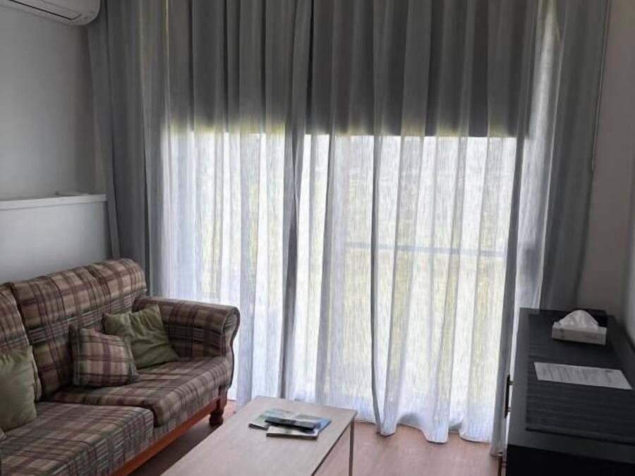 Una sala de estar con un sofá, una mesa de centro y un escritorio con una computadora.