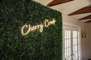 Un mur orné d’un panneau néon sur lequel on peut lire « Cherry Creek ».