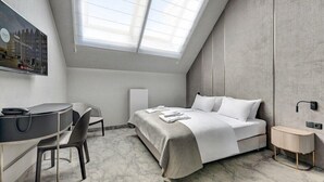 A modern bedroom with a skylight, a bed, a desk, and a chair. - Hotel Grano Gdansk SPA & Wellness (Gdańsk)