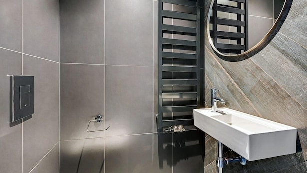 A modern bathroom with a rectangular sink, a towel rack, and a shower area. - Hotel Grano Gdansk SPA & Wellness (Gdańsk)