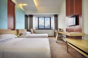 A hotel room with two beds, a desk, a chair, a TV, and a large window with a mountain view. - Minhang Hotel (Guilin Railway Station & Elephant Trunk Hill Park Branch) (Guilin)