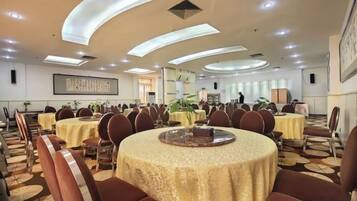 A conference room with round tables, chairs, and a large window.