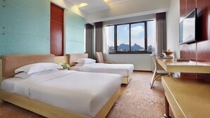 A hotel room with two beds, a desk, a TV, and a large window with a city view. - Minhang Hotel (Guilin Railway Station & Elephant Trunk Hill Park Branch) (Guilin)