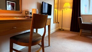 A hotel room with a wooden desk, a chair, a television, a lamp, and a mirror. - Relaxing Executive Double Room with Sofa in Blaby (Blaby)