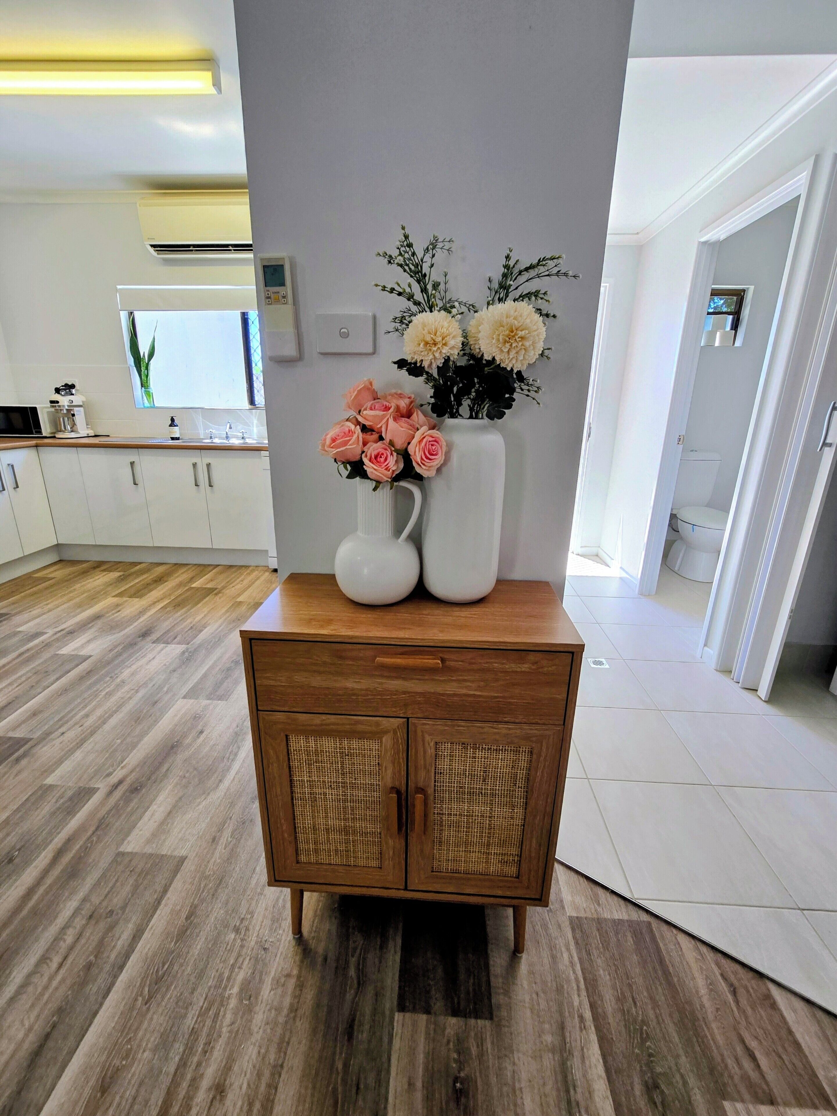 A modern kitchen with white cabinets, a wooden countertop, and a built-in oven.