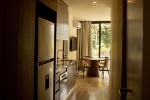 Eine moderne Küche mit Essbereich, Backofen und einem großen Fenster mit Vorhängen.