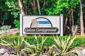 A sign for Calusa Campground with a beach scene illustration. - Happier in the keys- waterfront tiny home in Key Largo (Key Largo)