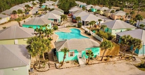 Um bairro residencial com várias casas, uma piscina e palmeiras.