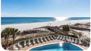 A pool with lounge chairs, a beach, and a clear sky. - Beach Front Family Friendly Sleeps 8 3pools Seaview Resort (Orange Beach)