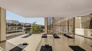 Un amplio espacio interior con grandes ventanales, diseño moderno y vistas a edificios.
