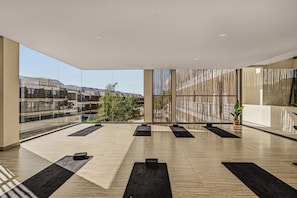 A spacious indoor area with large windows, a modern design, and a view of buildings outside. - Quiet 2BR Penthouse w Private Pool | Gym | CoWork (Tulum)