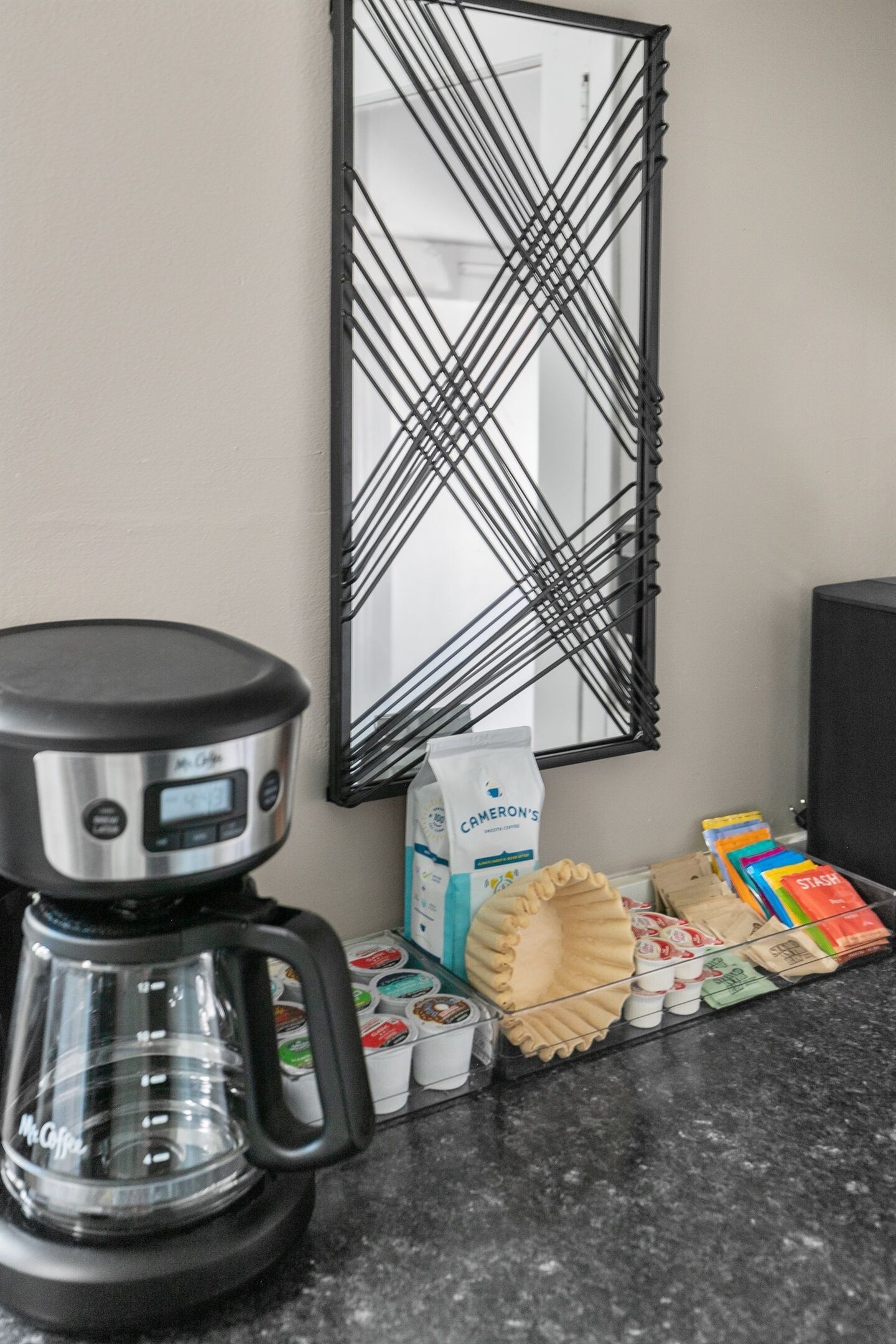 Una encimera de cocina con una cafetera, un cartón de leche y diversos alimentos.