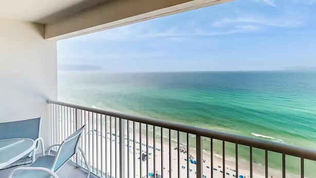 Ein Balkon mit Blick auf den Ozean und den Strand.